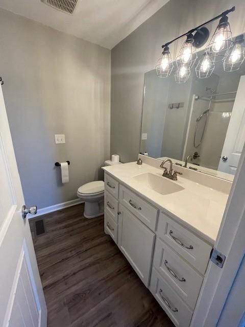 bathroom with wood-type flooring, vanity, and toilet