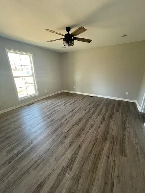 spare room with dark hardwood / wood-style floors and ceiling fan