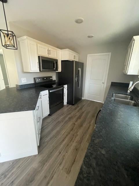 kitchen with white cabinetry, sink, hanging light fixtures, dark hardwood / wood-style flooring, and appliances with stainless steel finishes