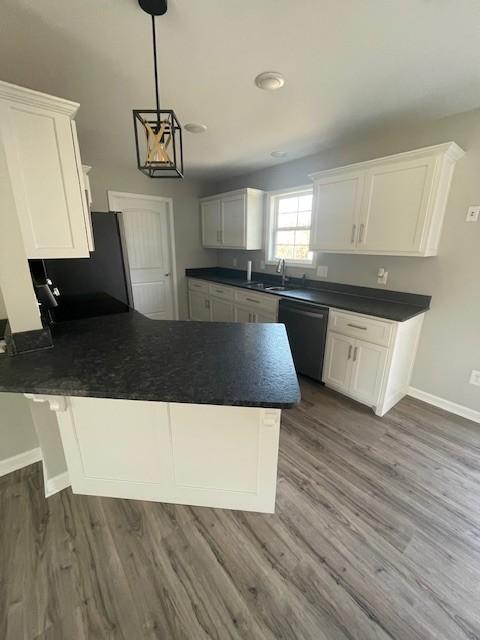 kitchen with dark hardwood / wood-style flooring, sink, pendant lighting, dishwasher, and white cabinetry