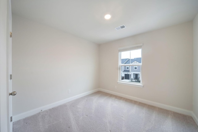 spare room featuring light colored carpet