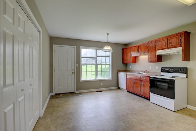 kitchen featuring pendant lighting, white appliances, and sink