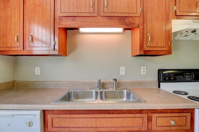 kitchen featuring white appliances, sink, and range hood