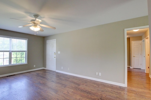 empty room with dark hardwood / wood-style floors and ceiling fan