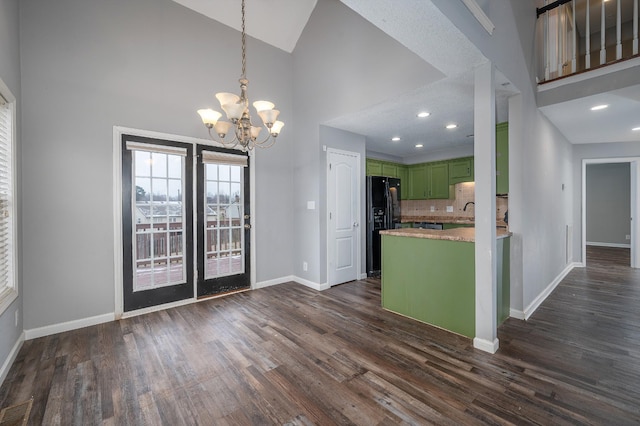 kitchen featuring green cabinets, black refrigerator with ice dispenser, high vaulted ceiling, and a chandelier