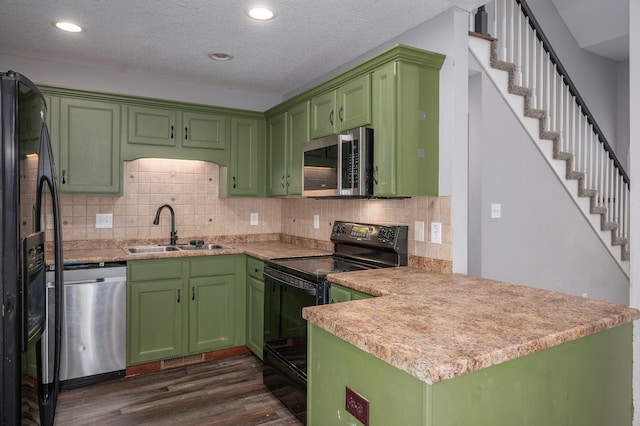 kitchen with sink, dark hardwood / wood-style flooring, kitchen peninsula, black appliances, and green cabinetry