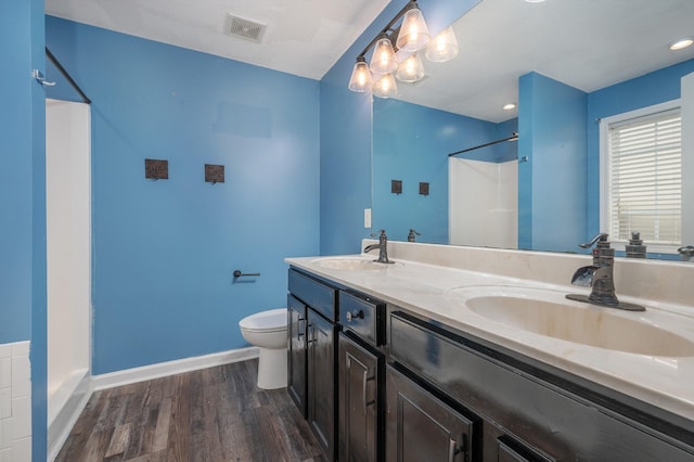 bathroom featuring a shower, vanity, wood-type flooring, and toilet