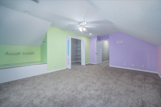 bonus room featuring carpet, a textured ceiling, ceiling fan, and lofted ceiling