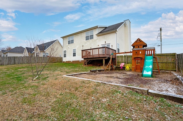 back of house featuring a playground, a lawn, and a deck