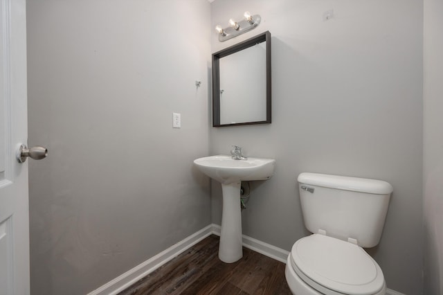 bathroom with hardwood / wood-style flooring and toilet