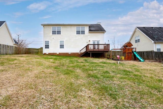 rear view of house with a playground, a lawn, and a deck