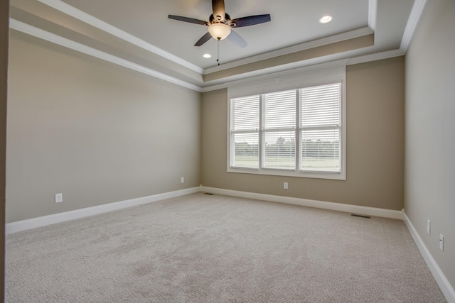 carpeted empty room with ornamental molding, a raised ceiling, and ceiling fan