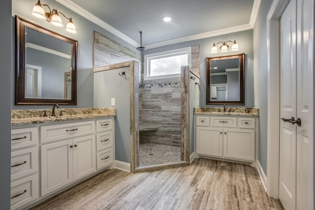 bathroom featuring a tile shower, vanity, crown molding, and wood-type flooring