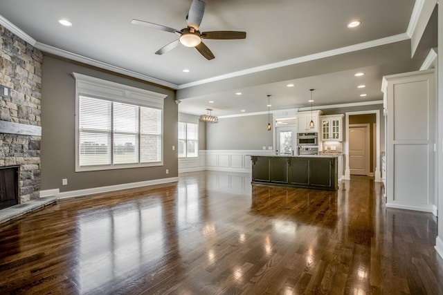 unfurnished living room with dark hardwood / wood-style flooring, a fireplace, and ornamental molding