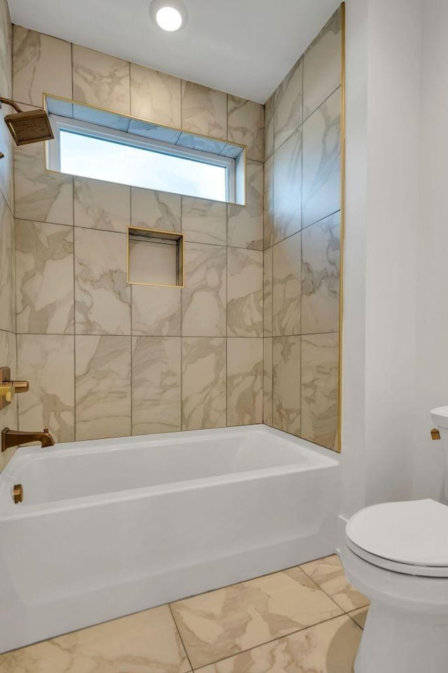 bathroom with tiled shower / bath and toilet