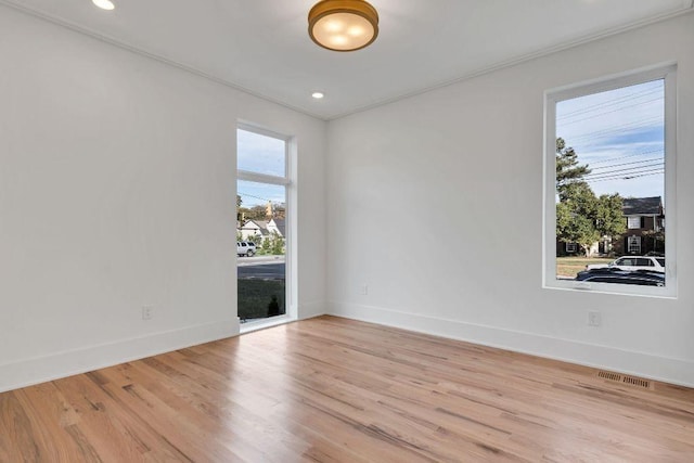 spare room with light hardwood / wood-style floors and ornamental molding