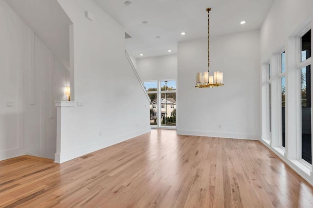 interior space featuring a chandelier, a high ceiling, and light hardwood / wood-style flooring