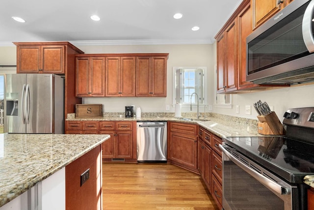 kitchen featuring sink, light hardwood / wood-style flooring, stainless steel appliances, light stone counters, and ornamental molding