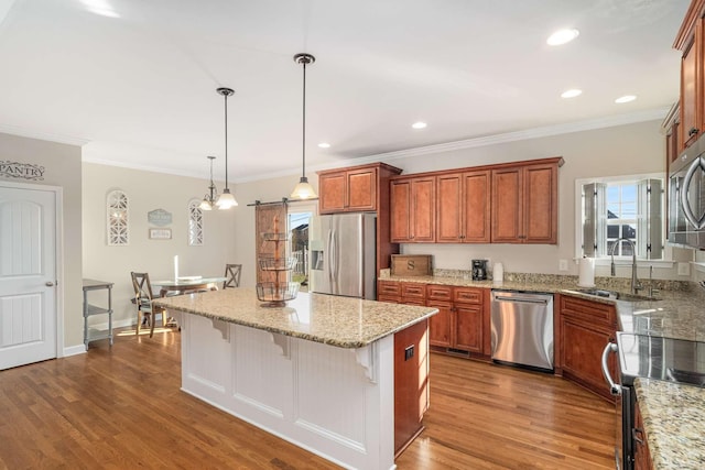 kitchen featuring pendant lighting, a breakfast bar, appliances with stainless steel finishes, a kitchen island, and a barn door