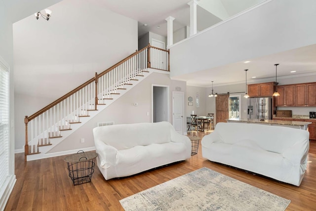 living room featuring wood-type flooring, a barn door, and a wealth of natural light