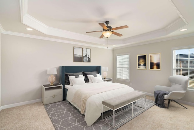 carpeted bedroom featuring ceiling fan, ornamental molding, and a tray ceiling