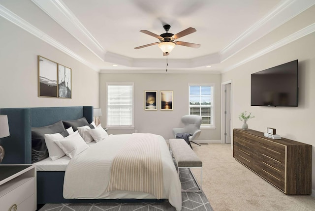 bedroom featuring crown molding, a raised ceiling, ceiling fan, and carpet