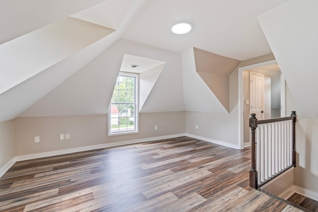 additional living space with dark hardwood / wood-style floors and vaulted ceiling