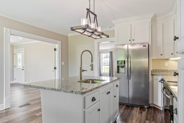 kitchen with white cabinetry, stainless steel fridge, sink, and a kitchen island with sink