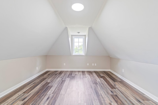 additional living space featuring lofted ceiling and dark wood-type flooring