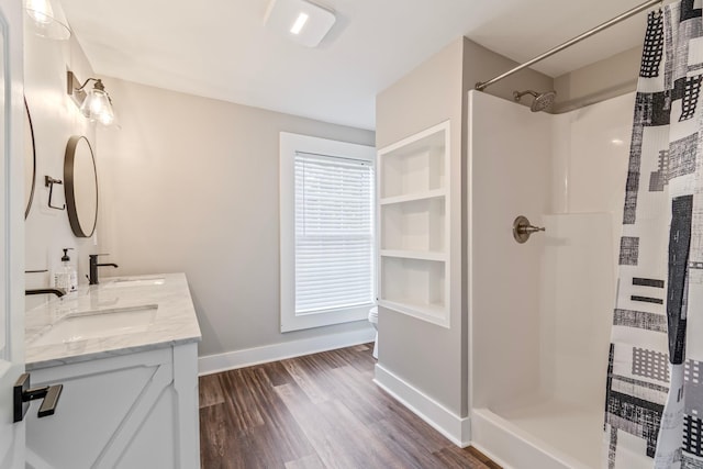 bathroom featuring toilet, vanity, wood-type flooring, and walk in shower