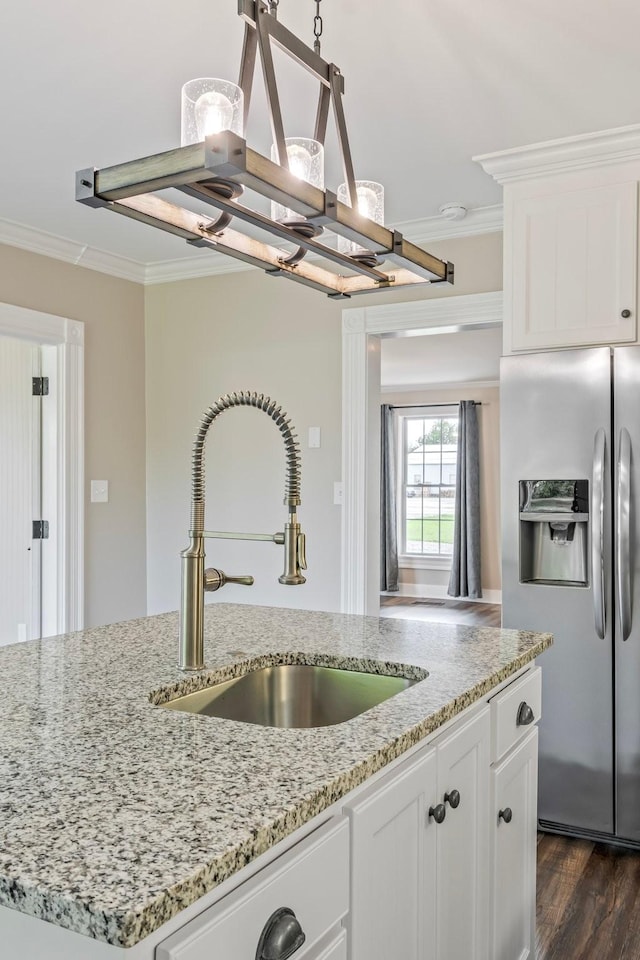 kitchen featuring white cabinets, sink, ornamental molding, and stainless steel refrigerator with ice dispenser