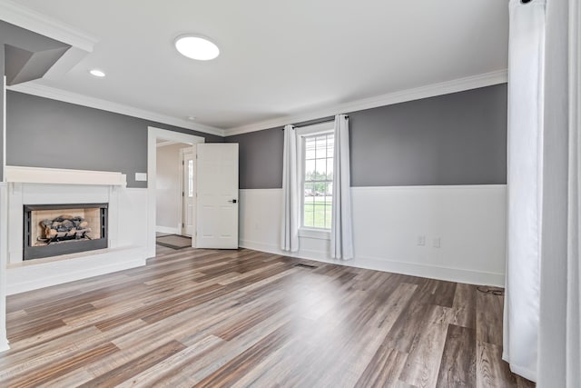 unfurnished living room featuring crown molding and wood-type flooring