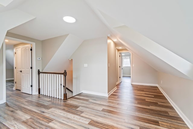 bonus room with hardwood / wood-style flooring and lofted ceiling