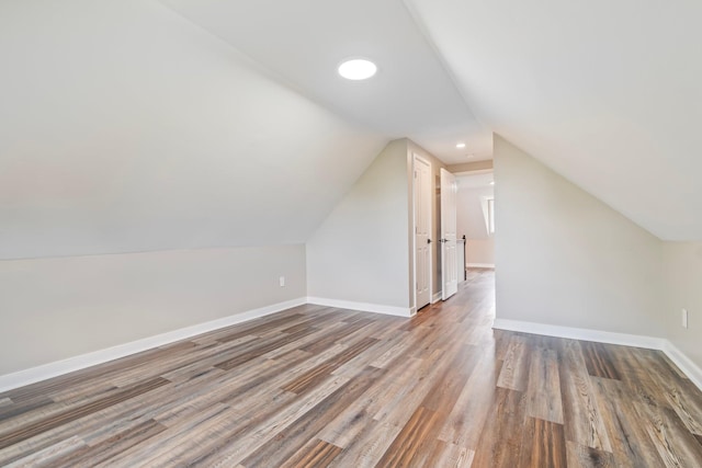 additional living space with lofted ceiling and hardwood / wood-style flooring