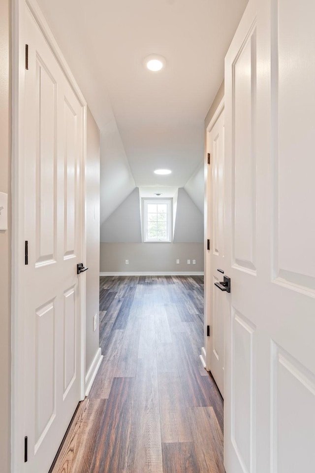 additional living space with dark wood-type flooring and vaulted ceiling