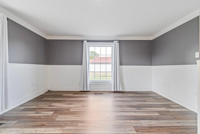 spare room with hardwood / wood-style flooring and crown molding