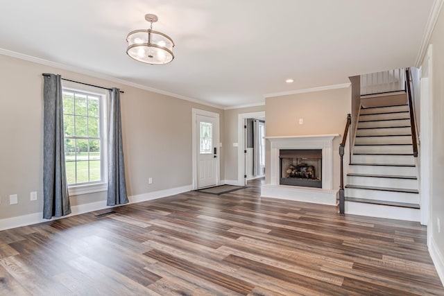 unfurnished living room with an inviting chandelier, crown molding, and dark wood-type flooring