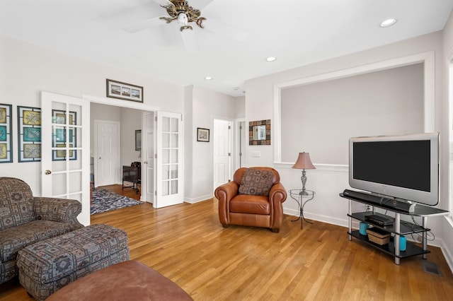 living room with ceiling fan, wood-type flooring, and french doors