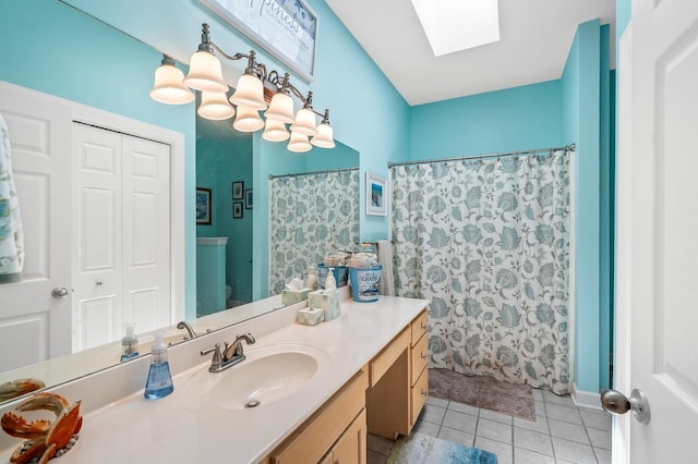 bathroom featuring vanity, a skylight, tile patterned floors, and walk in shower