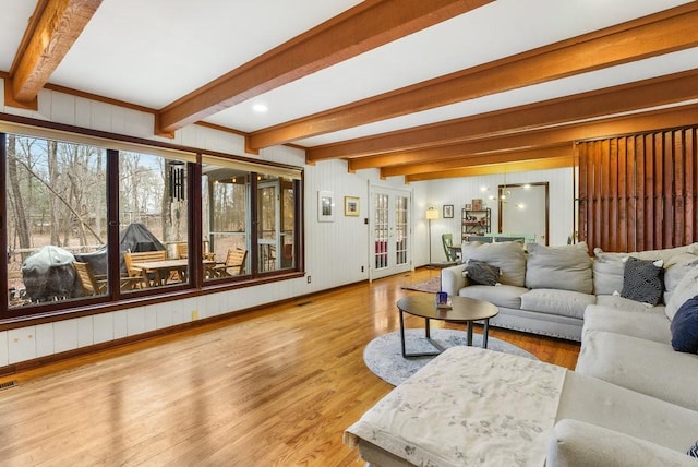 living room with beam ceiling and light hardwood / wood-style floors