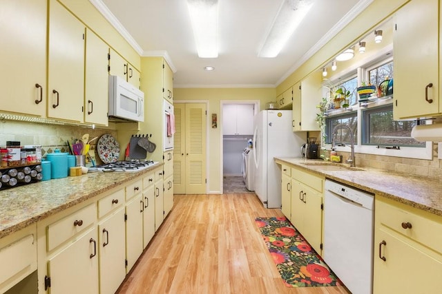 kitchen with tasteful backsplash, white appliances, sink, cream cabinets, and light hardwood / wood-style flooring