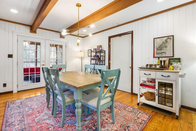 dining space with french doors, light wood-type flooring, and beam ceiling