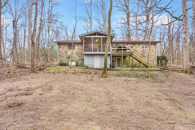 back of house featuring a wooden deck and a sunroom