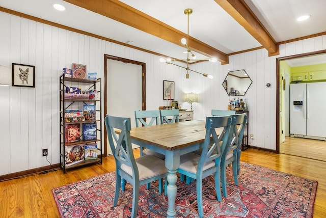 dining space with hardwood / wood-style floors, beam ceiling, and wooden walls