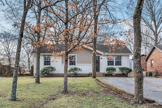 single story home featuring central AC unit and a front lawn