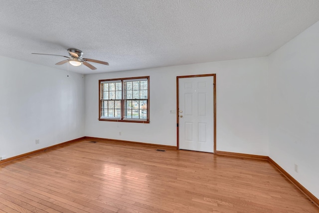 spare room with ceiling fan, light hardwood / wood-style floors, and a textured ceiling