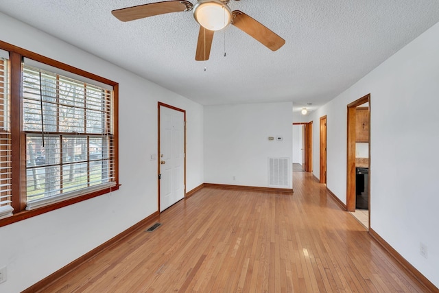 unfurnished room with ceiling fan, a textured ceiling, and light hardwood / wood-style flooring