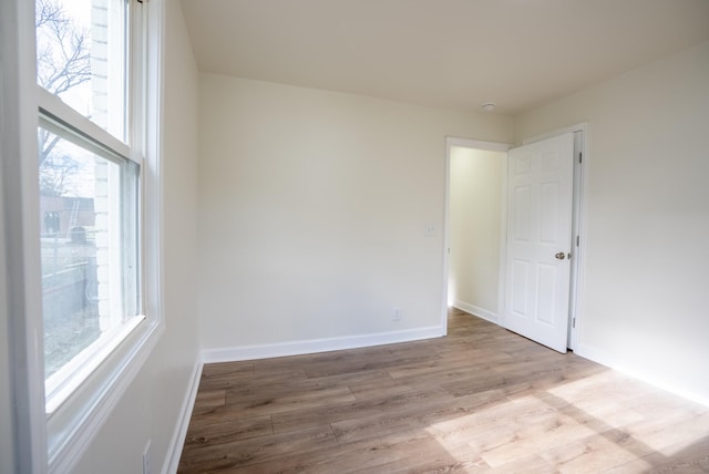 empty room with a healthy amount of sunlight and light hardwood / wood-style floors