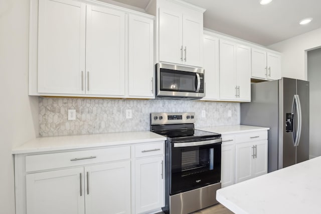 kitchen with stainless steel appliances, light countertops, and white cabinets