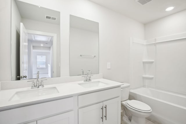 bathroom featuring toilet, double vanity, a sink, and visible vents